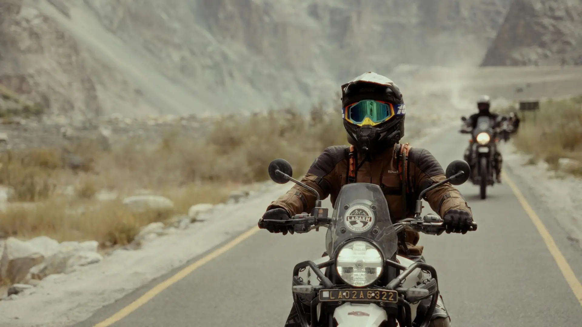 Biker wearing helmet on motorcycle on rugged mountain road. Adventure awaits!